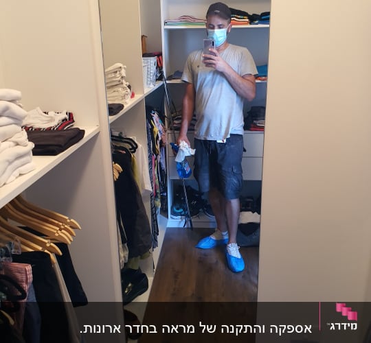 אדם מצלם את עצמו במראה בחדר ארונות